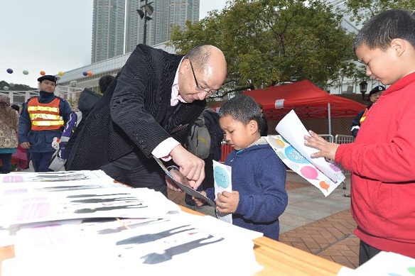 Mr Tam distributes souvenirs to the public to appeal for greater support for the "Consultation Document on the Methods for Selecting the Chief Executive in 2017 and for Forming the Legislative Council in 2016". Leaflets of the Consultation Document in six ethnic minority languages are available for collection at the event.