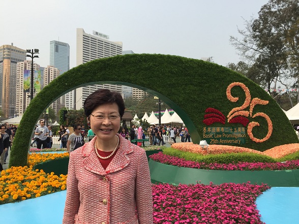 政務司司長林鄭月娥攝於香港花卉展覽內「《基本法》頒布25周年」園圃前。