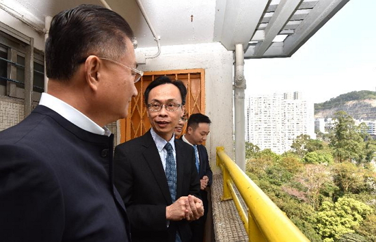 The Secretary for Constitutional and Mainland Affairs, Mr Patrick Nip, visited Kwun Tong District today (March 23). Picture shows Mr Nip (second left) reminiscing his childhood days in Ping Shek Estate where he formerly lived.