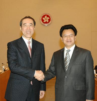 政务司司长唐英年（左）今日上午（六月二十三日）在香港举行粤港合作联席会议第十一次工作会议前，欢迎广东省副省长万庆良（右）。