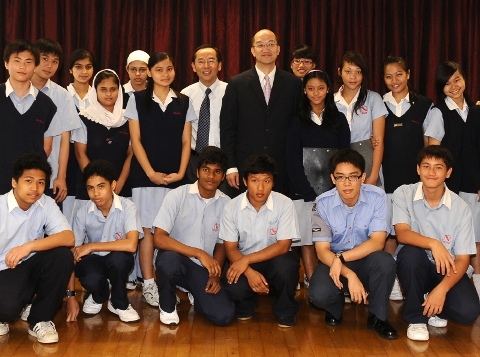 While visiting the school, Mr Tam met with a group of students who shared with him their school life and their experience in adapting to the local community. Photo shows Mr Tam taking a group photo with the students.