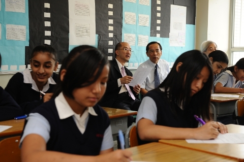 Photo shows Mr Tam sitting in a Hindi lesson to understand how the non-Chinese speaking students learn an ethnic minority language in class.