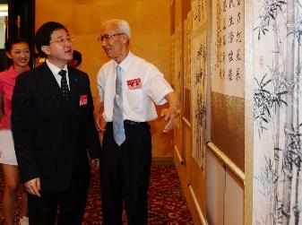 Mr Lam is briefed by famous artist and calligraphist Hu Zhongyuan at the International Conference Centre of Liyuan Resort this morning (June 11) at an exhibition of Hu's artworks in commemoration of the 60th National Anniversary .