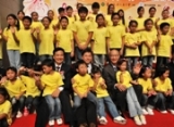 Photograph shows Mr Lam with members of the Wong Tai Sin Children's Choir performing at the event.