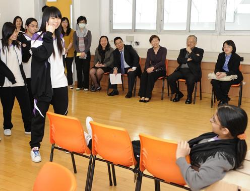 Photo shows Miss Wong sitting in on a drama class, during which local students and non-Chinese speaking students interacted with one another and practised acting together.