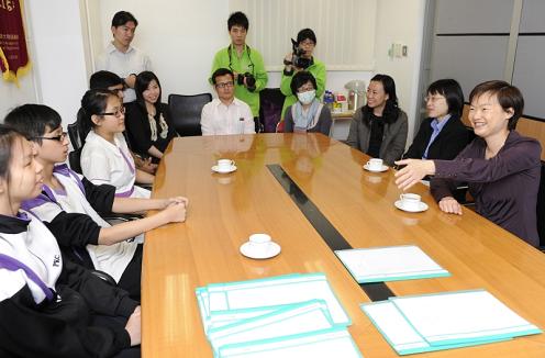 Photo shows Miss Wong chatting with students during a meeting session.