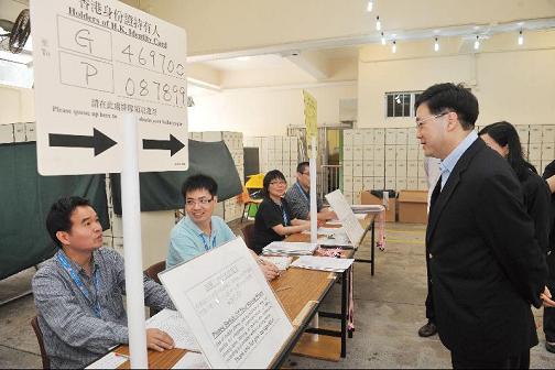 The Secretary for Constitutional and Mainland Affairs, Mr Stephen Lam, this morning (May 16) visited a Legislative Council by-election polling station set up at the Tang Shiu Kin Victoria Government Secondary School polling station at Oi Kwan Road, Wan Chai. Photo shows Mr Lam chatting with staff members.