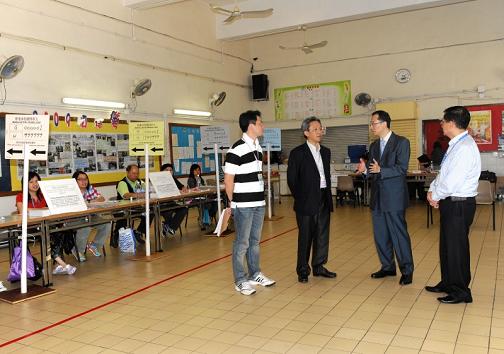 Photo shows the Permanent Secretary for Constitutional and Mainland Affairs, Mr Joshua Law (second from left), visiting a Legislative Council by-election polling station set up at the STFA Tam Pak Yu College at Yau Oi Road, Yau Oi Estate, Tuen Mun this afternoon (May 16).