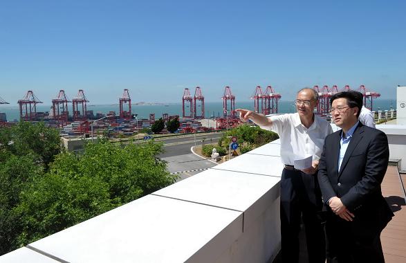 Photo shows Mr Lam being briefed by staff members of the Yangshan Deep Water Port on the operation of the container terminal during his visit there this (August 20) morning.