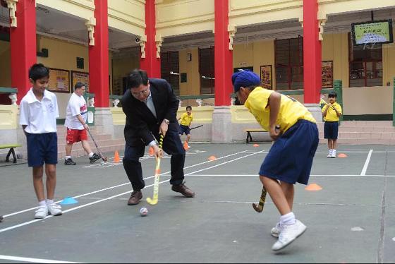 The Secretary for Constitutional and Mainland Affairs, Mr Stephen Lam, visited Wan Chai District this afternoon (November 9) to get an update on the district. Mr Lam first saw for himself various extra-curricular activities attended by the students during his visit to the Po Kok Primary School at Shan Kwong Road, Happy Valley. Photo shows Mr Lam participating in hockey training with the students at the school.