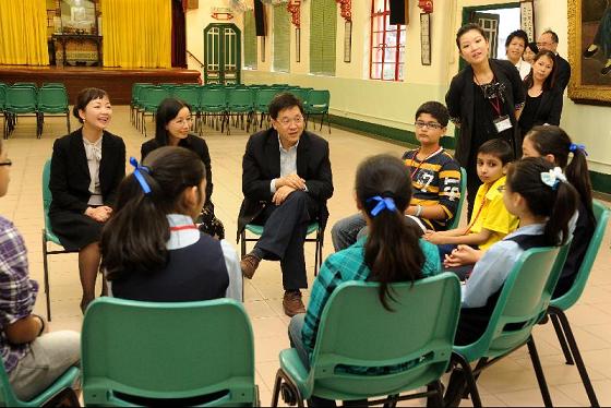 圖示林瑞麟與寶覺小學各班級的不同國籍的學生代表交談，分享學習和生活體驗。
