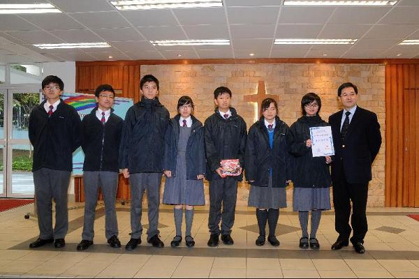 The Secretary for Constitutional and Mainland Affairs, Mr Stephen Lam, visited CNEC Christian College this afternoon (December 16) to gain a first-hand understanding of the teaching and education situation at the school. Photo shows Mr Lam (right) with the winners of a Form Two inter-class Putonghua advertisement competition after presenting the prizes.