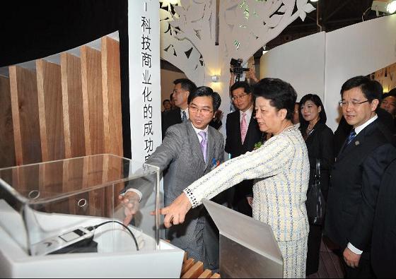 Mr Lam (first right) and Mr So (fourth right) accompany the Vice-Chairperson of the Standing Committee of the National People's Congress, Ms Chen Zhili (third right), to visit the Hong Kong Pavilion.
