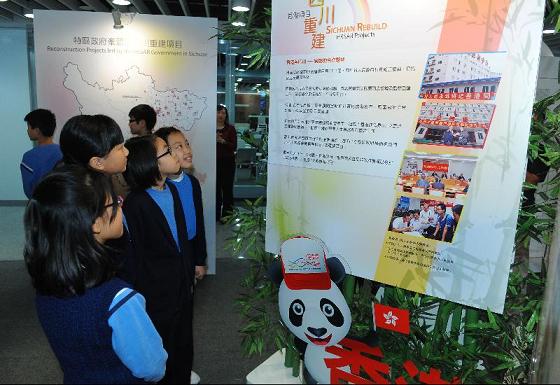 Students from Tai Po Old Market Public School take an interest in a display detailing the HKSAR's reconstruction efforts.