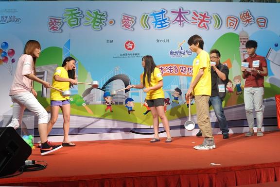歌手胡鴻鈞（右）在「愛香港．愛《基本法》同樂日」與現場觀眾一同參與《基本法》遊戲環節，與眾同樂。