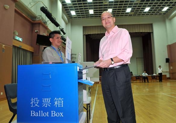譚志源示範在地方選區議席選舉中投票。