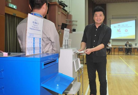Mr Yuen demonstrates how to cast a vote in the District Council (second) functional constituency.