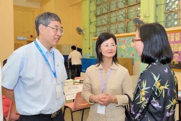 The Permanent Secretary for Constitutional and Mainland Affairs, Ms Chang King Yiu (second left), chatted with the working staff during her visit to the polling station at the Hennessy Road Government Primary School, Wan Chai, this morning (September 9).