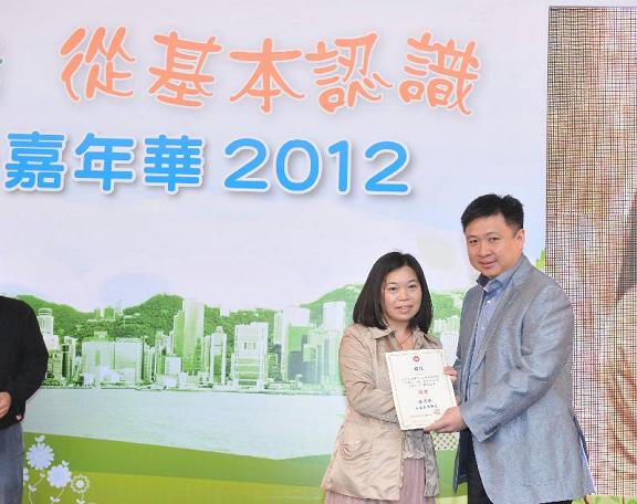 Winner of the "Basic Law Photo-taking Competition to commemorate the 15th Anniversary and of the establishment of the HKSAR" receives a prize from the member of the Working Group on Civil Servants under the Basic Law Promotion Steering Committee, Dr Eugene Chan (right).