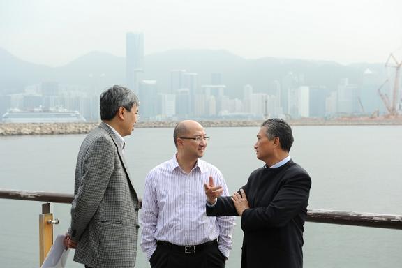 Mr Tam (centre) is briefed by Mr Au (left) and Mr Chan (right) on the latest developments of the Kwun Tong Promenade.