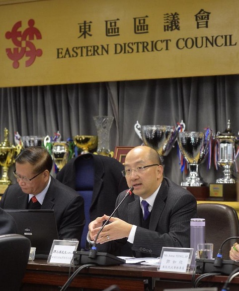 譚志源（右）出席東區區議會會議，向議員簡介諮詢文件。