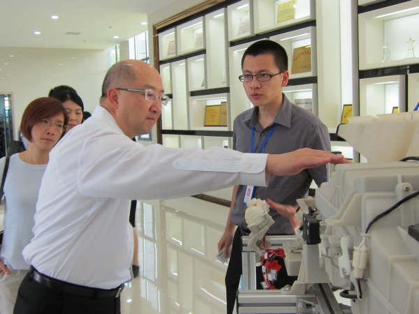 Mr Tam (left) is briefed on the technology of 3D printing while touring a company in the Changsha National High-Tech Industrial Development Zone.