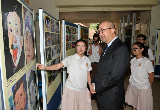 A student introduces school artworks to Mr Tam.