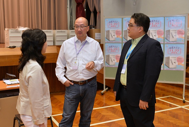 The Secretary for Constitutional and Mainland Affairs, Mr Raymond Tam, visits the polling station in the Fung Tak Constituency at Fung Tak Estate Community Centre, Wong Tai Sin this evening (November 22) to see for himself the operation of the District Council Ordinary Election. Photo shows Mr Tam (centre) receiving a briefing by the Presiding Officer.