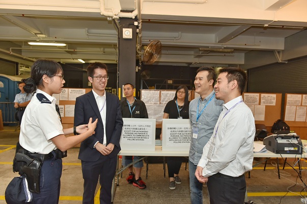 The Under Secretary for Constitutional and Mainland Affairs, Mr Ronald Chan (first right), visits the dedicated polling station at Happy Valley Police Station this morning (November 22) to learn more about its operation.