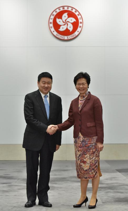 Mrs Lam (right) shakes hands with Mr Liang before the conference.