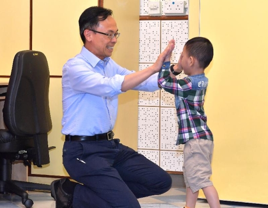 The Secretary for Constitutional and Mainland Affairs, Mr Patrick Nip, visited the Yan Chai Hospital Yuen Yuen Institute Early Education and Training Centre today (July 28). Picture shows Mr Nip giving a high-five to encourage a child under rehabilitative training.