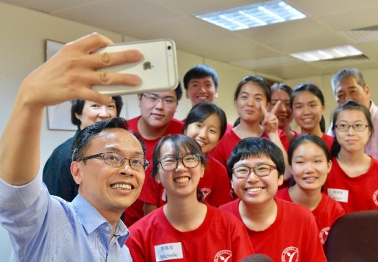 The Secretary for Constitutional and Mainland Affairs, Mr Patrick Nip, takes a selfie with members of the Tsuen Wan District Youth Corps today (July 28).