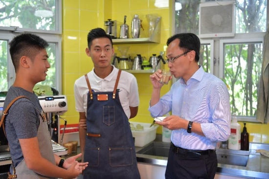 The Secretary for Constitutional and Mainland Affairs, Mr Patrick Nip (right), today (August 29) tastes the coffee brewed by a student of a coffee-making class while visiting the Kam Tin Glocal Youth Hub.