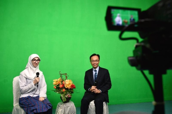 The Secretary for Constitutional and Mainland Affairs, Mr Patrick Nip (right), does a recording for the campus TV of Islamic Kasim Tuet Memorial College to share his thoughts on his visit with teachers and students today (November 17).
