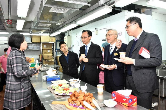 The Secretary for Constitutional and Mainland Affairs, Mr Patrick Nip (third right), visits Lok Sin Tong Meal Delivery Service Centre today (December 11) to learn more about its operation and service scope.