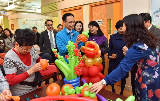 The Secretary for Constitutional and Mainland Affairs, Mr Patrick Nip, visited the Hong Kong Sheng Kung Hui Wong Tai Sin District Elderly Community Centre in Wong Tai Sin today (January 25). Photo shows staff members of the centre showing Mr Nip (third left) artwork made by the elderly in a balloon twisting class.