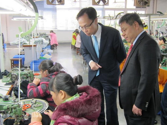 The Secretary for Constitutional and Mainland Affairs, Mr Patrick Nip (second right), tours a knitting factory run by a Hong Kong enterprise in Huizhou today (February 6) to learn more about the operation of the company and business opportunities in the city.