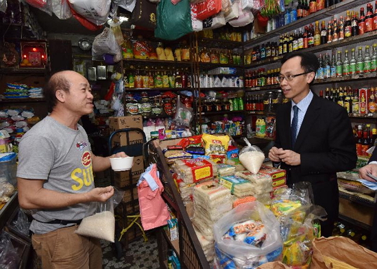 The Secretary for Constitutional and Mainland Affairs, Mr Patrick Nip, visited Kwun Tong District today (March 23). Picture shows Mr Nip (right) chatting with an acquaintance at Ping Shek Estate where he formerly lived.