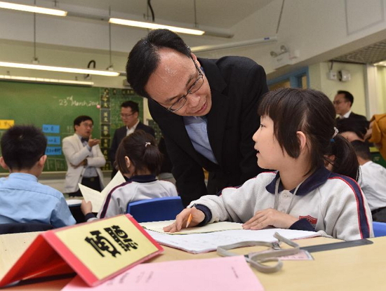 The Secretary for Constitutional and Mainland Affairs, Mr Patrick Nip, chats with a student participating in the 333 Learning Companion Leadership Program organised by the We R Family Foundation at Buddhist Chi King Primary School today (March 23) to learn about how she copes with her learning.