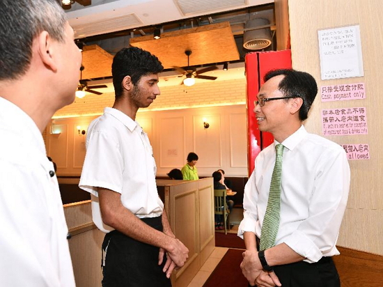 The Secretary for Constitutional and Mainland Affairs, Mr Patrick Nip, today (April 3) toured a catering enterprise which has recently adopted the Code of Practice against Discrimination in Employment on the Ground of Sexual Orientation. Picture shows Mr Nip (right) chatting with an ethnic minority employee to learn about his work.