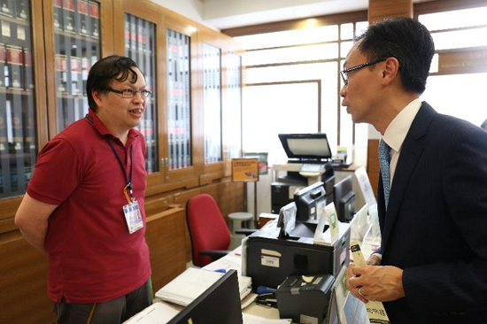 The Secretary for Constitutional and Mainland Affairs, Mr Patrick Nip, visited the Basic Law Library today (August 24). Picture shows Mr Nip (right) chatting with a staff member to learn about the daily operation of the library.