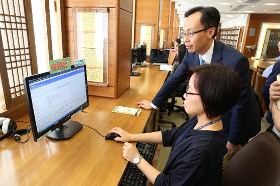 The Secretary for Constitutional and Mainland Affairs, Mr Patrick Nip, visited the Basic Law Library today (August 24). Picture shows Mr Nip (right) watching a demonstration on the use of online database workstations in the library.
