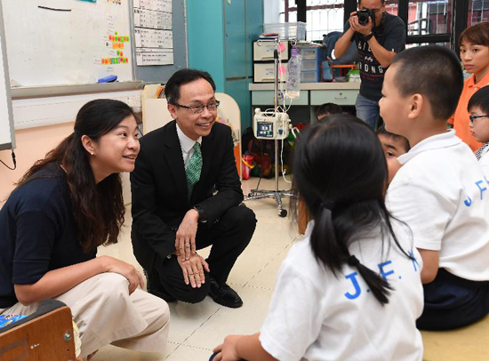The Secretary for Constitutional and Mainland Affairs, Mr Patrick Nip, visited a special school in Southern District today (September 26). Picture shows Mr Nip (second left) meeting a teacher and students to understand more about the teaching situation in the school.