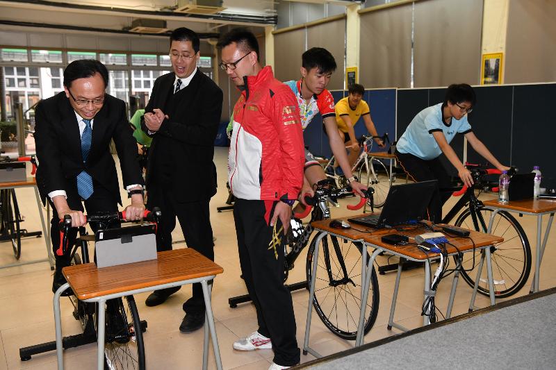 The Secretary for Constitutional and Mainland Affairs, Mr Patrick Nip, visited a secondary school in Sai Kung District this afternoon (December 28). Photo shows Mr Nip (left) trying out a bike in the school’s cycling room.