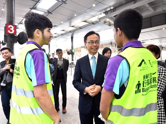 The Secretary for Constitutional and Mainland Affairs, Mr Patrick Nip, visited the Islands District today (January 31) and saw for himself the implementation of the "Luggage Ambassador", a scheme jointly organised by the Airport Authority Hong Kong and a non-government organisation in Tung Chung. Picture shows Mr Nip (centre) chatting with two ethnic minority youngsters, who are working as luggage ambassadors, at a taxi stand in the airport.
