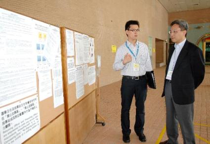 The Permanent Secretary for Constitutional and Mainland Affairs, Mr Joshua Law (right), is briefed by the District Officer (Sha Tin), Mr Andrew Lai, when visiting the Yan Oi Tong Hong Kong Toi Shan Association No. 2 Elderly Centre Polling Station in Fo Tan this (September 7) afternoon.
